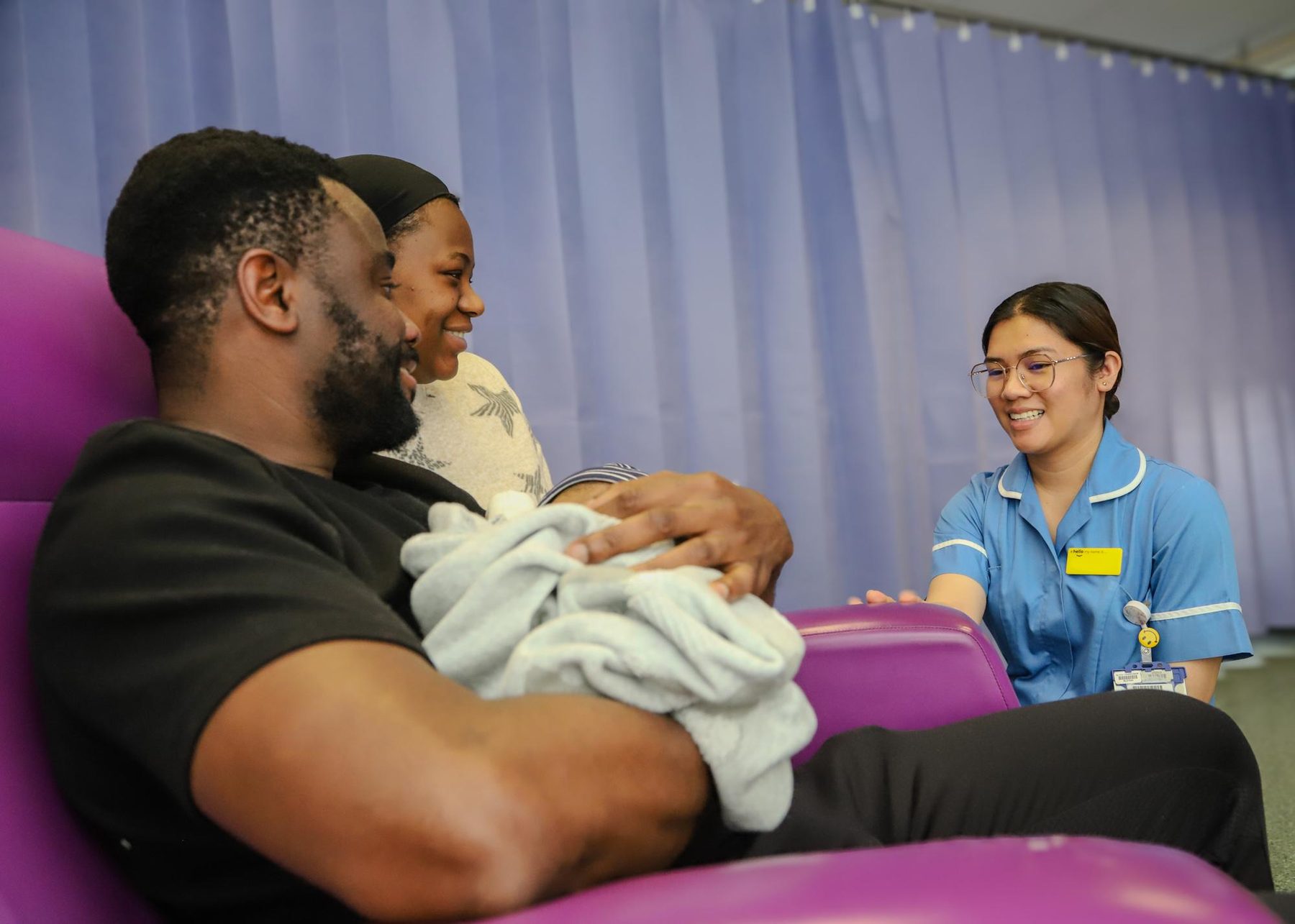 Parents holding their newborn baby on a maternity ward